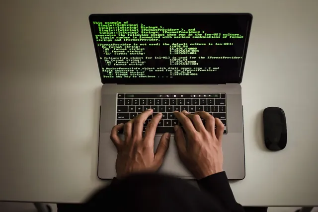 Hände bei der Arbeit an einer Webanwendung auf einem Laptop